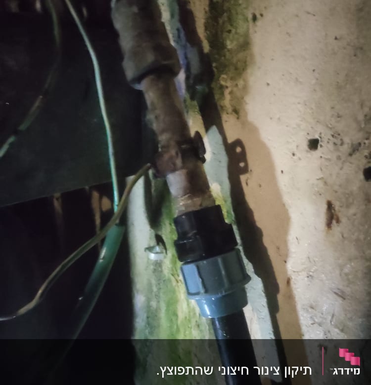 צינור מים עם חיבור פלסטיק על קיר לח